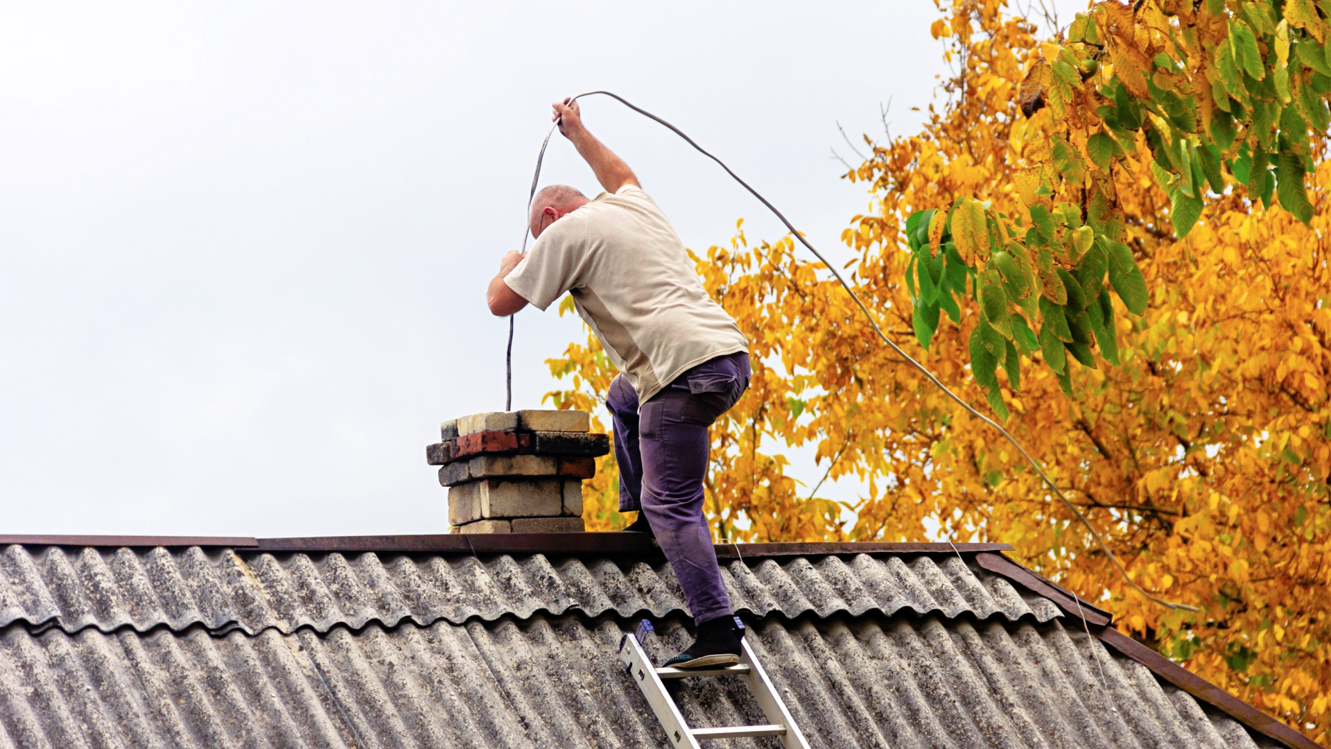 Man performing fall preventive maintenance on his home.